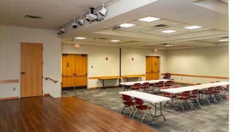 Linda Sickles Meeting Rooms A & B - view from stage with tables and chairs on the main floor