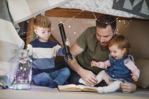 father reading with kids in fort