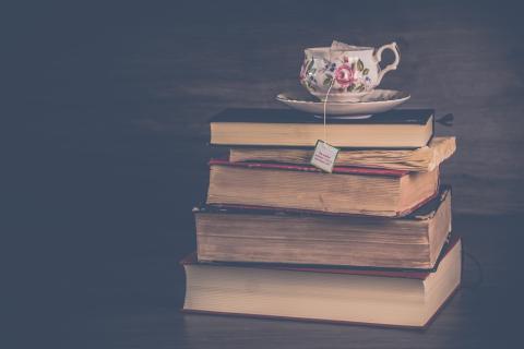 Stack of books with a cup of tea.