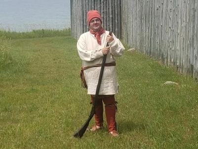 Picture of man dressed in historic costume with musket.