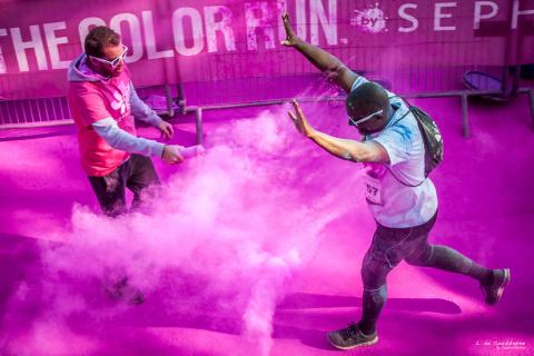 person running with color being thrown on them