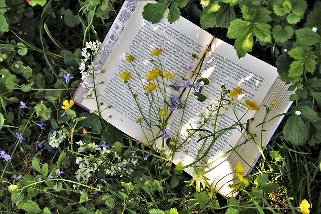 Photograph of a book in the grass covered by flowers