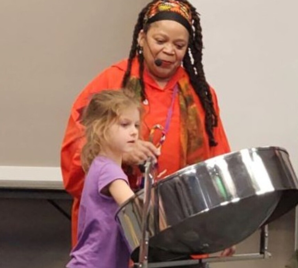 Ms Audrey and a child playing the steel drums