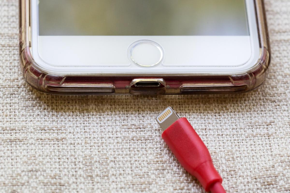iPhone with a red charging cord near the charging port